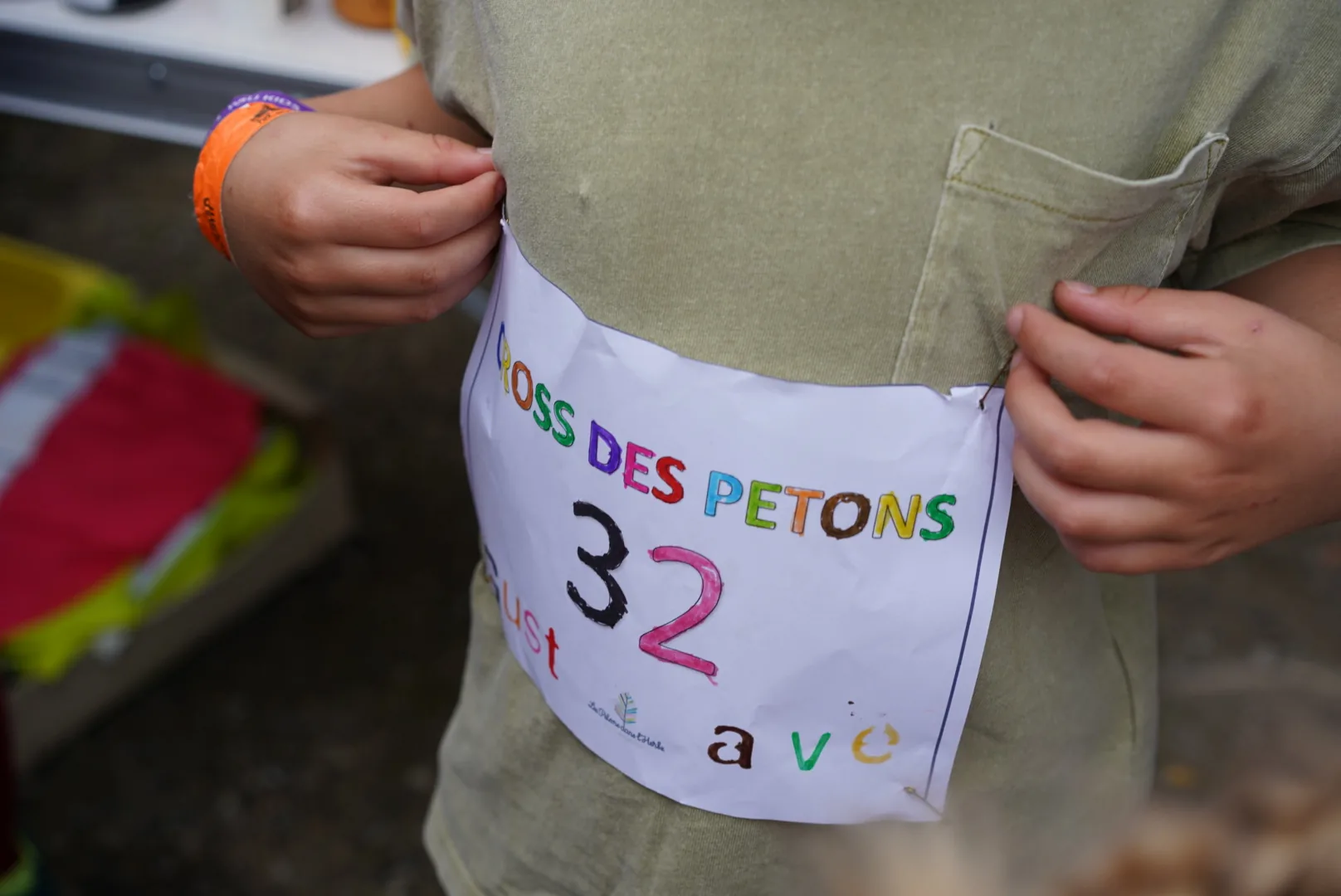 Un enfant prépare son dossard pour le cross des Petons.